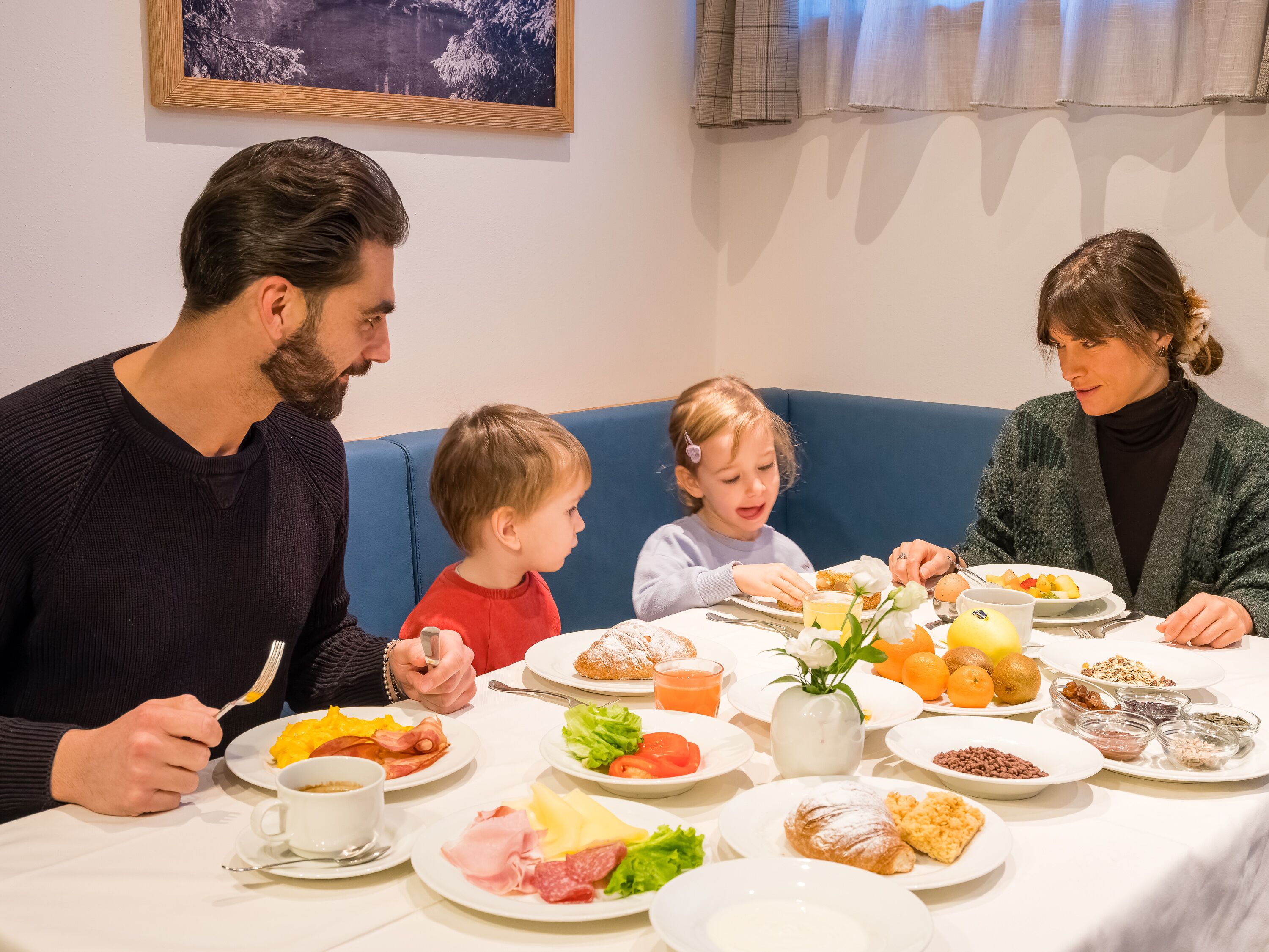 Eine Familie genießt ein Frühstück an einem Tisch.