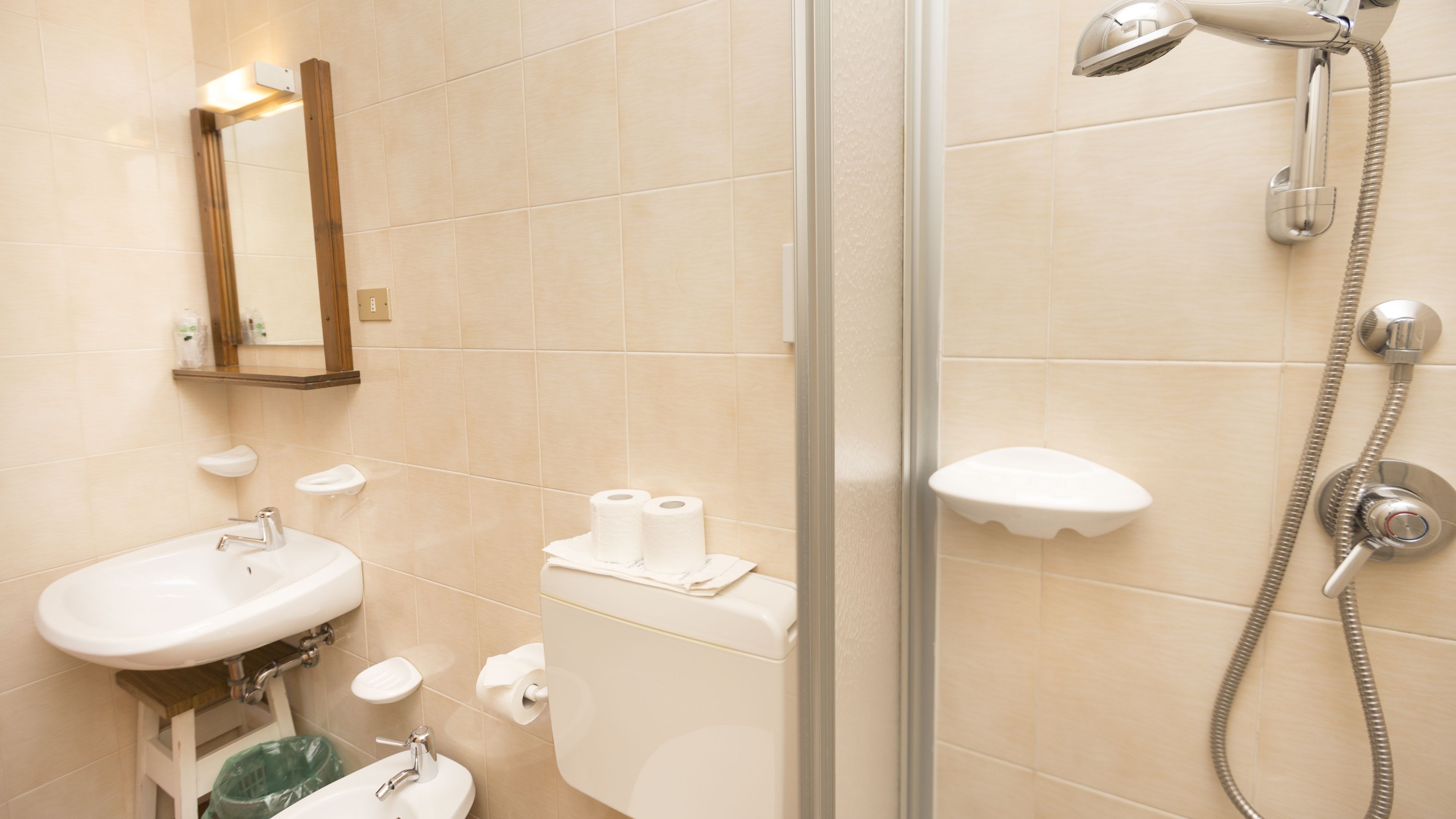 A modern bathroom with a glass-enclosed shower, a sink, and a mirror.