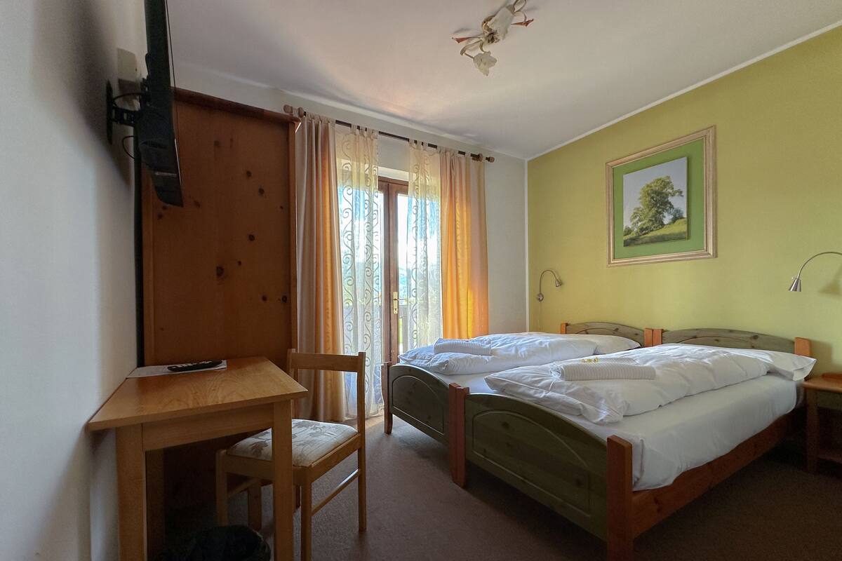 A room with a bed, a desk, and a chair.