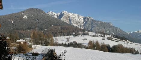 A snow-covered landscape with mountains in the background and a clear sky.