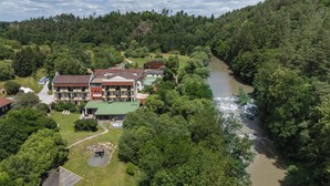 Un hotel con varias construcciones, piscina y un río.