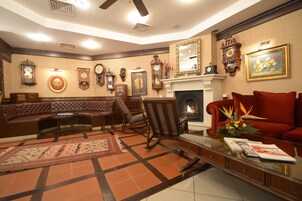 Una sala de estar tradicional con chimenea, un sofá de cuero, sillones y una mesa de centro.