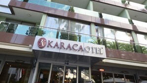 A hotel with a modern design, featuring a prominent sign for "Karacaotel". - Karaca Otel (Izmir)