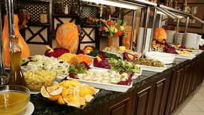 A buffet with various food items and a decorative centerpiece. - Karaca Otel (Izmir)