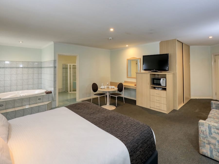 Escritorio, tabla de planchar con plancha y ropa de cama