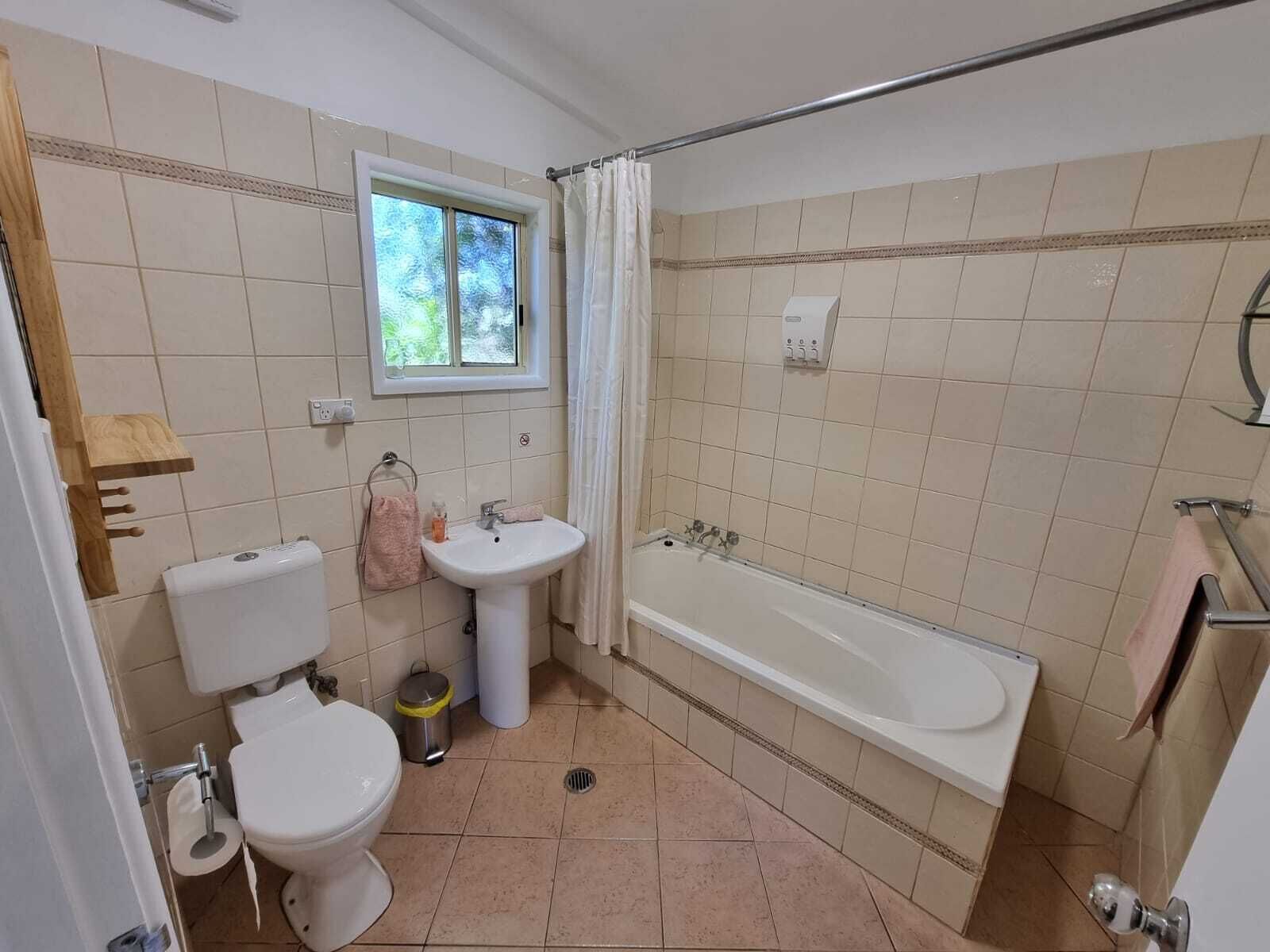 A bathroom with a toilet, sink, and bathtub.