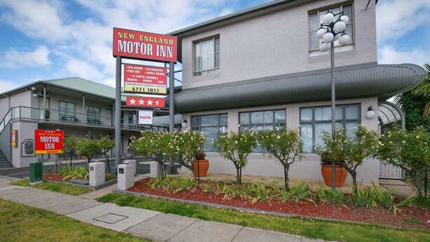 A motel with a signboard advertising amenities like SPA rooms, free Wi-Fi, and a 24-hour front desk.
