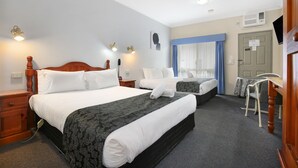 A hotel room with two beds, a desk, and a chair. There are wall-mounted lights and an air conditioning unit. - New England Motor Inn (Armidale)