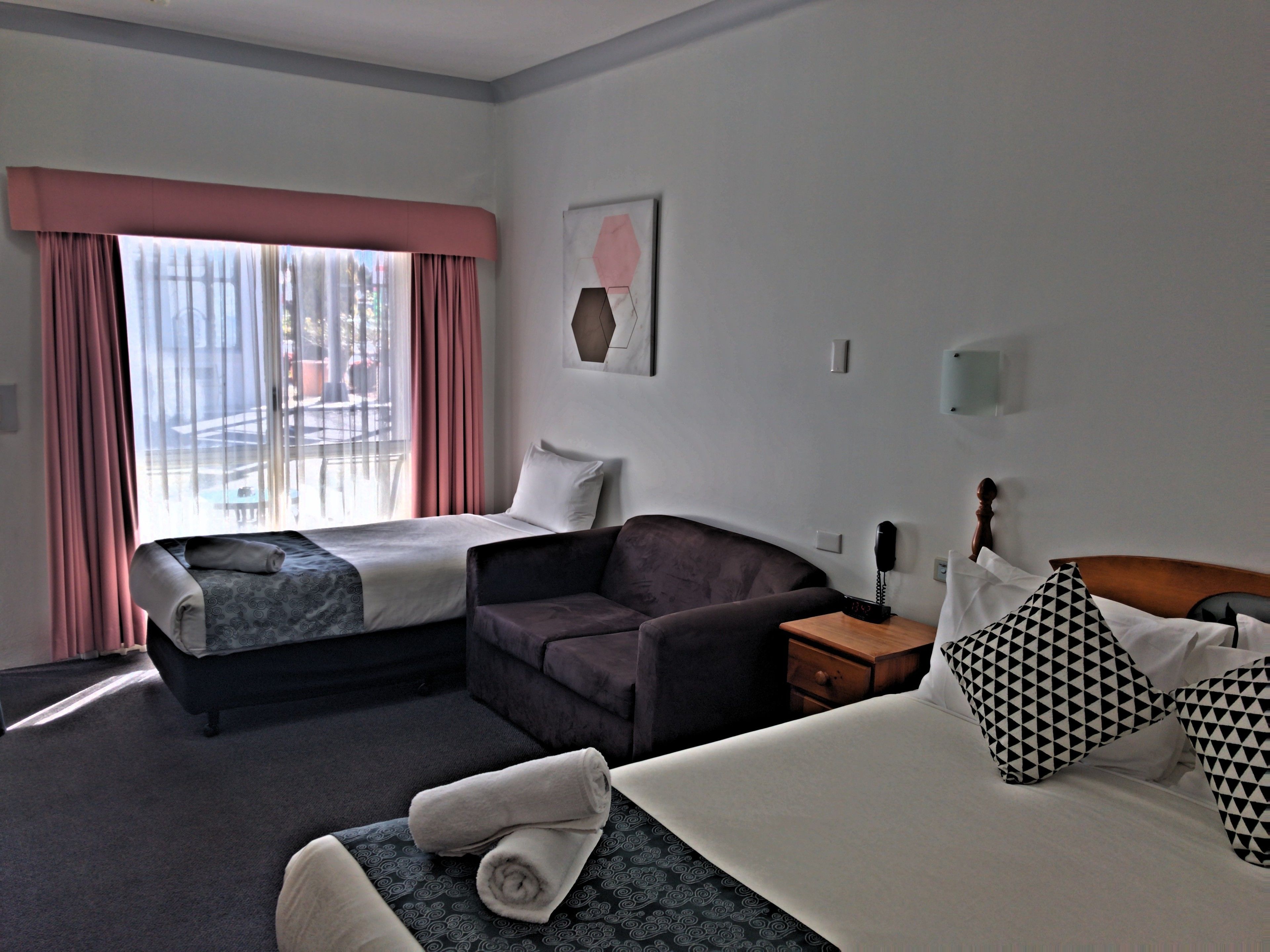 Une chambre d’hôtel avec un lit, un canapé, un bureau et une chaise.