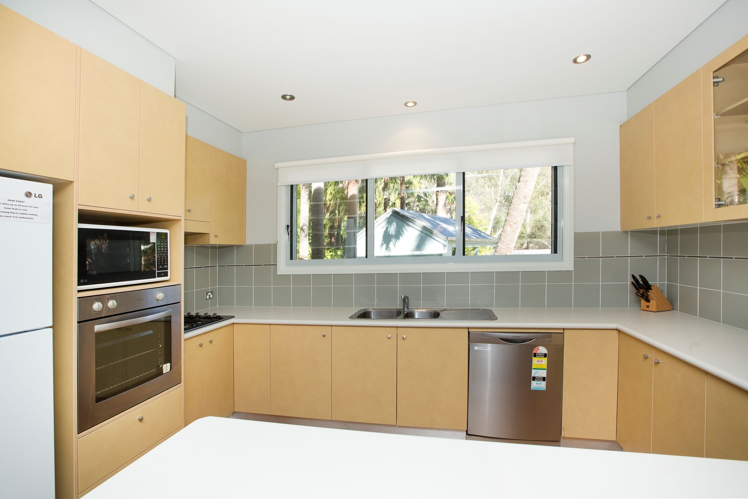 Una cocina moderna con electrodomésticos integrados, un ventanal y vistas al exterior.