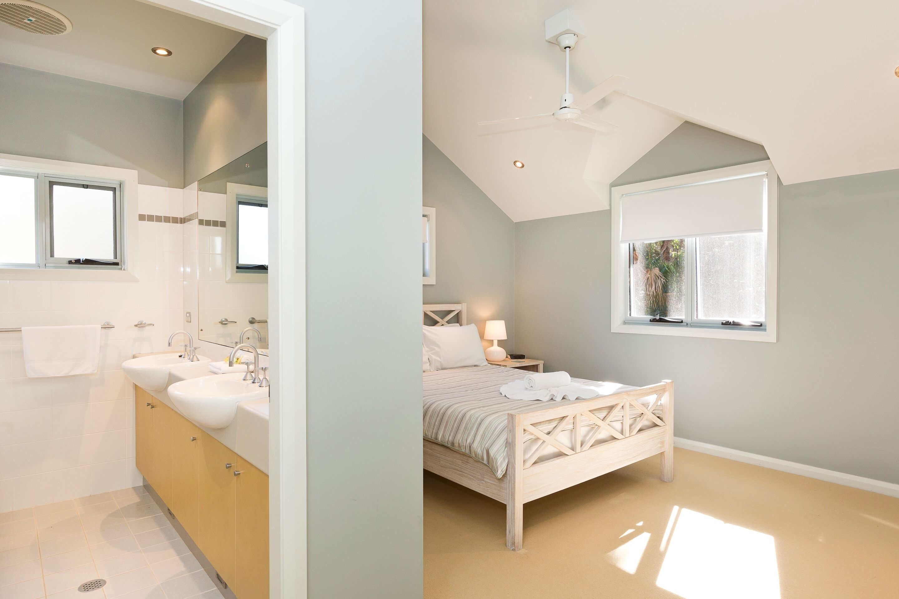 A modern bedroom with a bed, bedside table, and window.