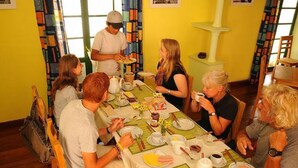 Un grupo de personas cenando en una mesa con diversos platos y bebidas.