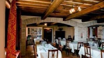 A restaurant with wooden beams, white tablecloths, and a rustic interior.