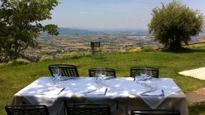 A table set for four with a view of a valley.
