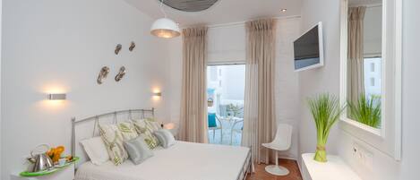 A modern bedroom with a bed, bedside table, TV, and a view of the outdoors.