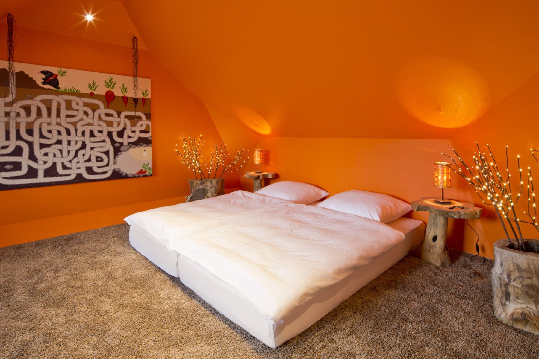 Un dormitorio con una cama grande, dos mesitas de noche y una lámpara de pared.