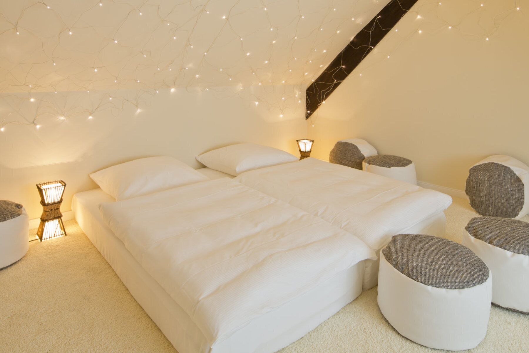 Un dormitorio con una cama grande, lámparas de noche y luces en el techo.