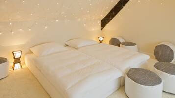 Un dormitorio con una cama grande, lámparas de noche y luces en el techo.