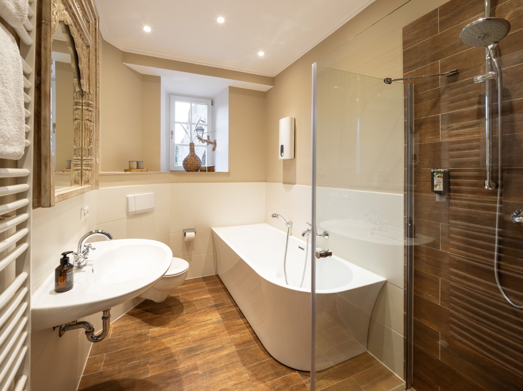 A modern bathroom with a freestanding bathtub, a glass-enclosed shower, and a large mirror.