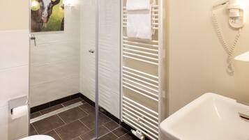 A modern bathroom with a toilet, shower, and sink.