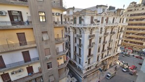 Un edifici d'edificis amb balcons, aparells d'aire condicionat i un carrer a baix.