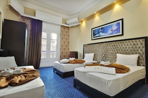 A hotel room with two beds, a large window, an air conditioning unit, and a framed picture on the wall. - Cairo Paradise Hotel (Cairo)