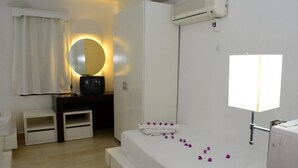 A hotel room with a bed, a bedside table, a mirror, an air conditioning unit, and a window. - Bodrum Park Hotel (Bodrum)