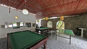 A billiards room with multiple tables, a brick wall, and a red metal roof. - Bodrum Park Hotel (Bodrum)