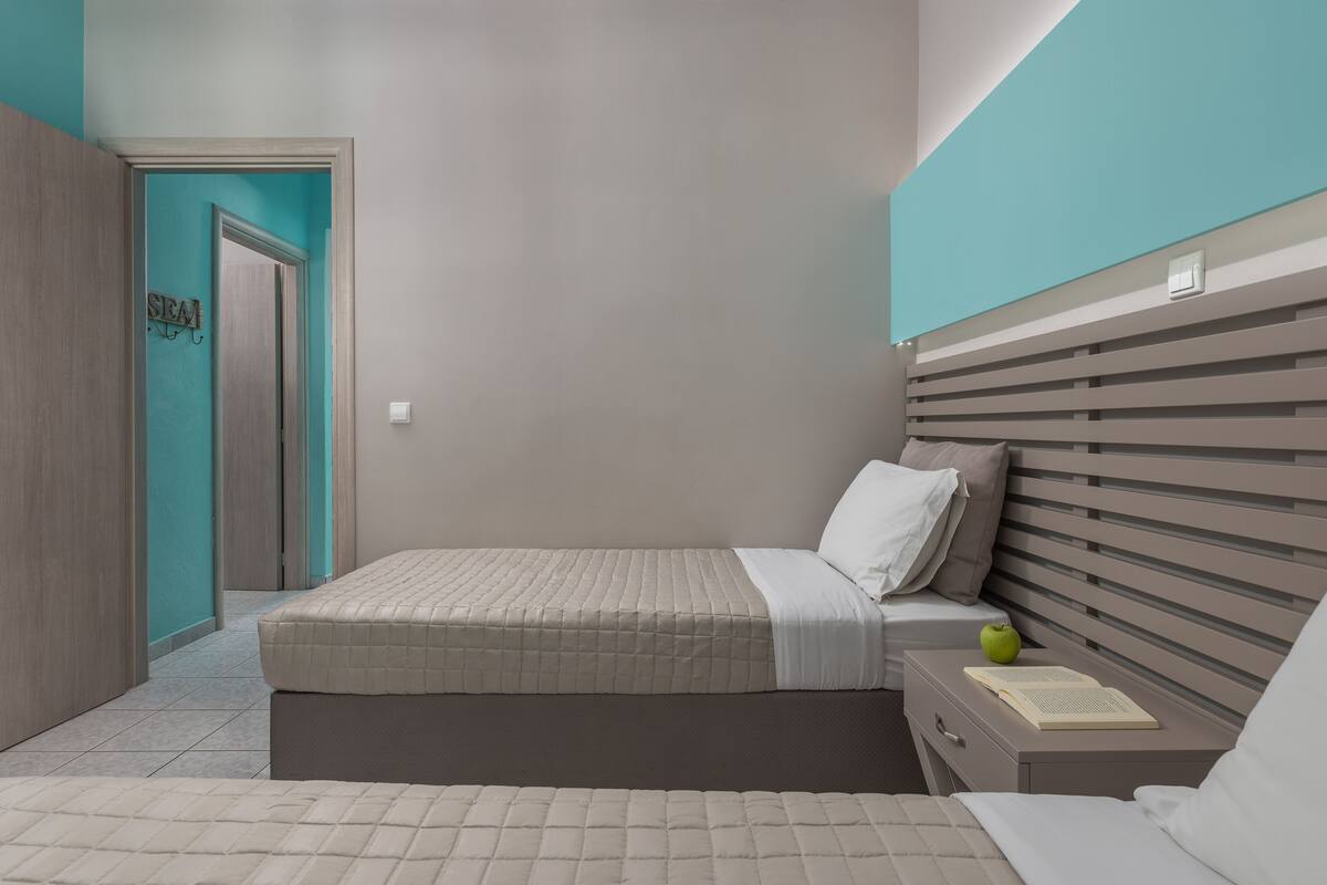 A bedroom with a bed, a nightstand, and a door.