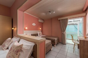 A hotel room with two beds, a desk, a chair, a balcony with a view, and a ceiling with a light fixture. - Ouzas Luxury Hotel (Katerini)