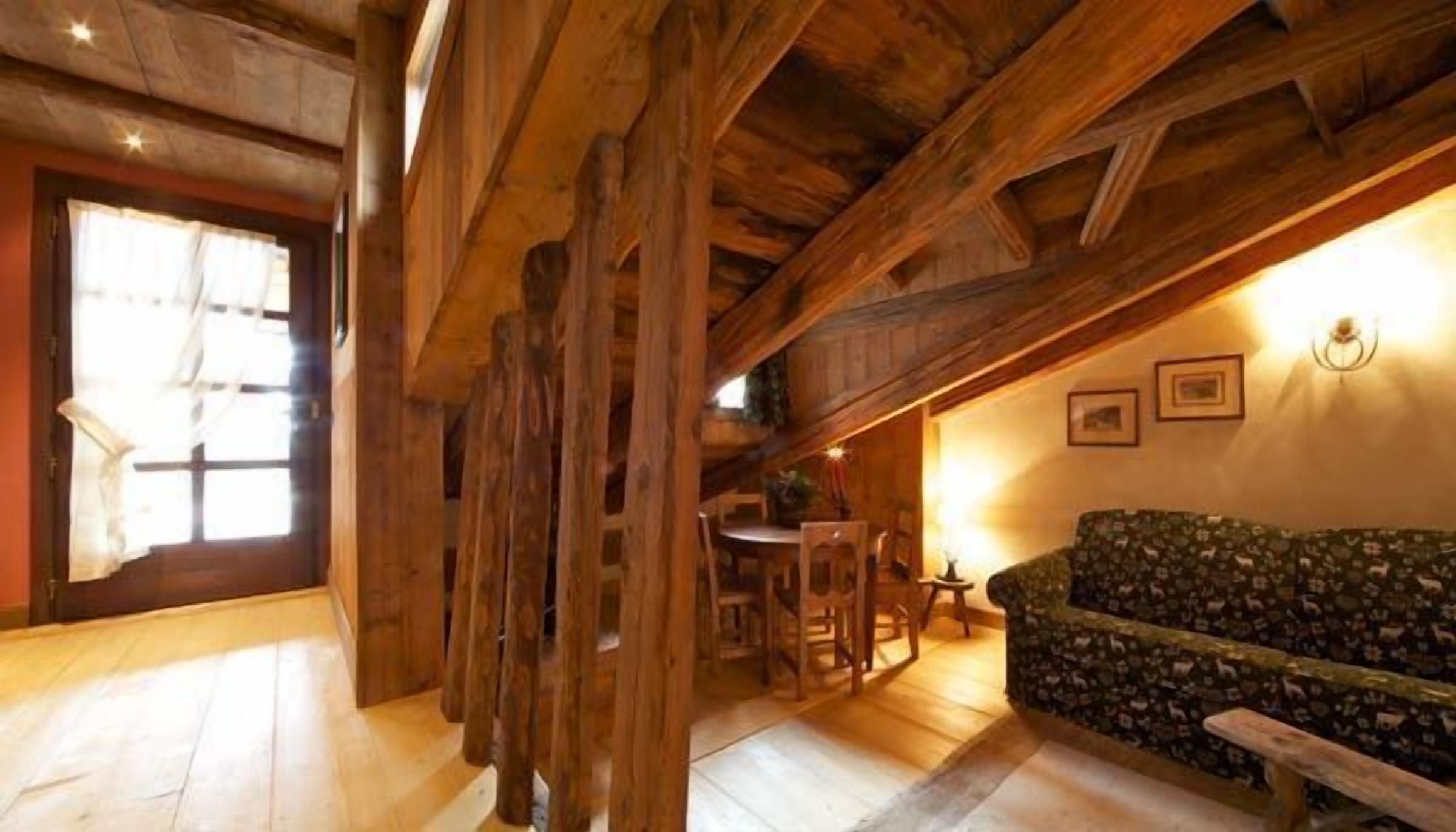 Ein Holzinnenraum mit Essbereich, einer Couch und einer Treppe.
