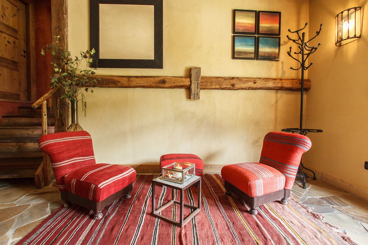 A cozy room with two red upholstered chairs, a small table, and a wooden bench.