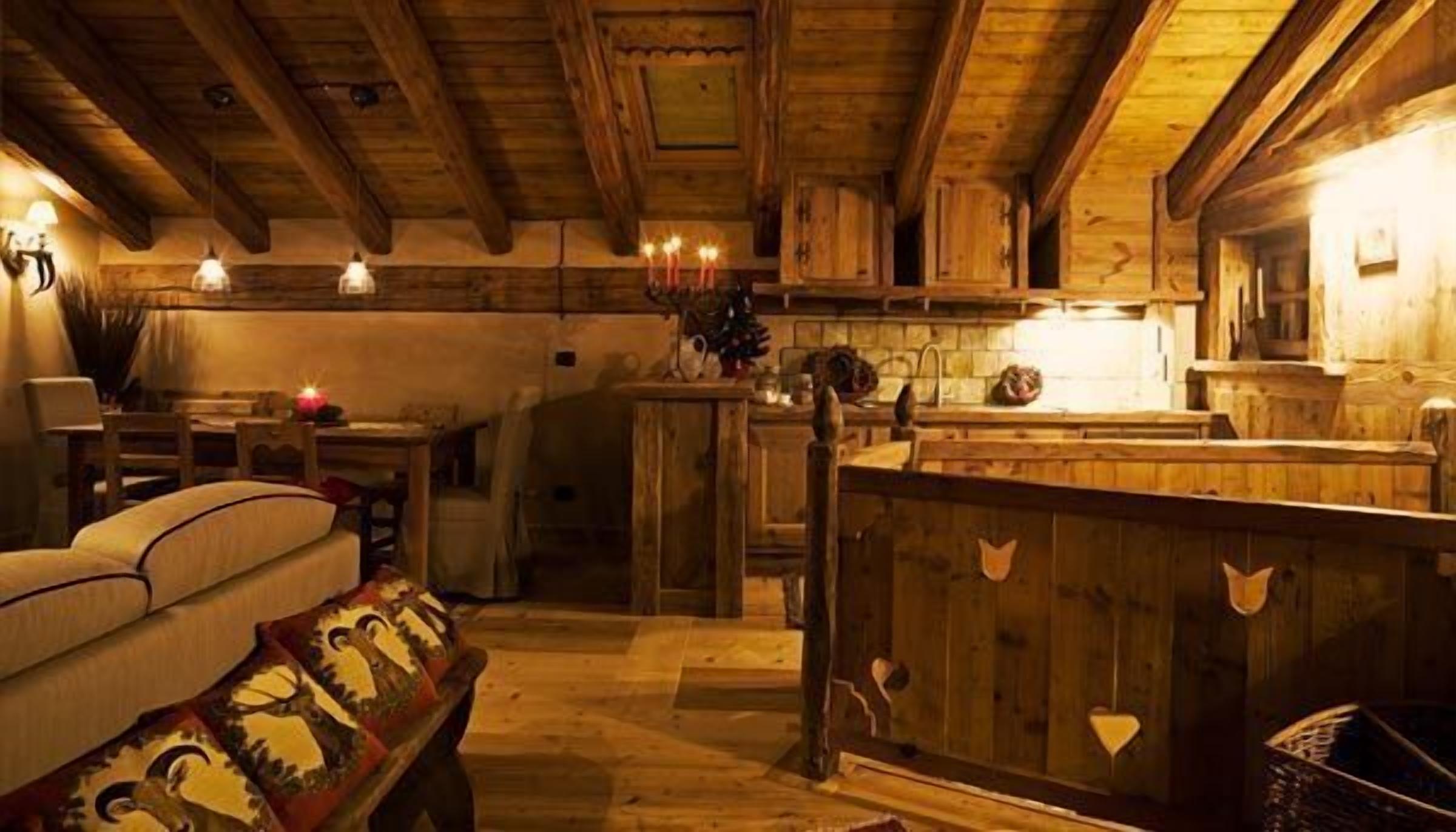 Ein rustikales Holzinterieur mit einer Couch, einem Esstisch und einer Küchenzeile.