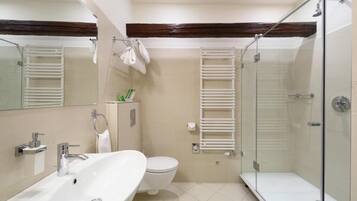 Een moderne badkamer met een wastafel, toilet en douchecabine met glazen wanden.