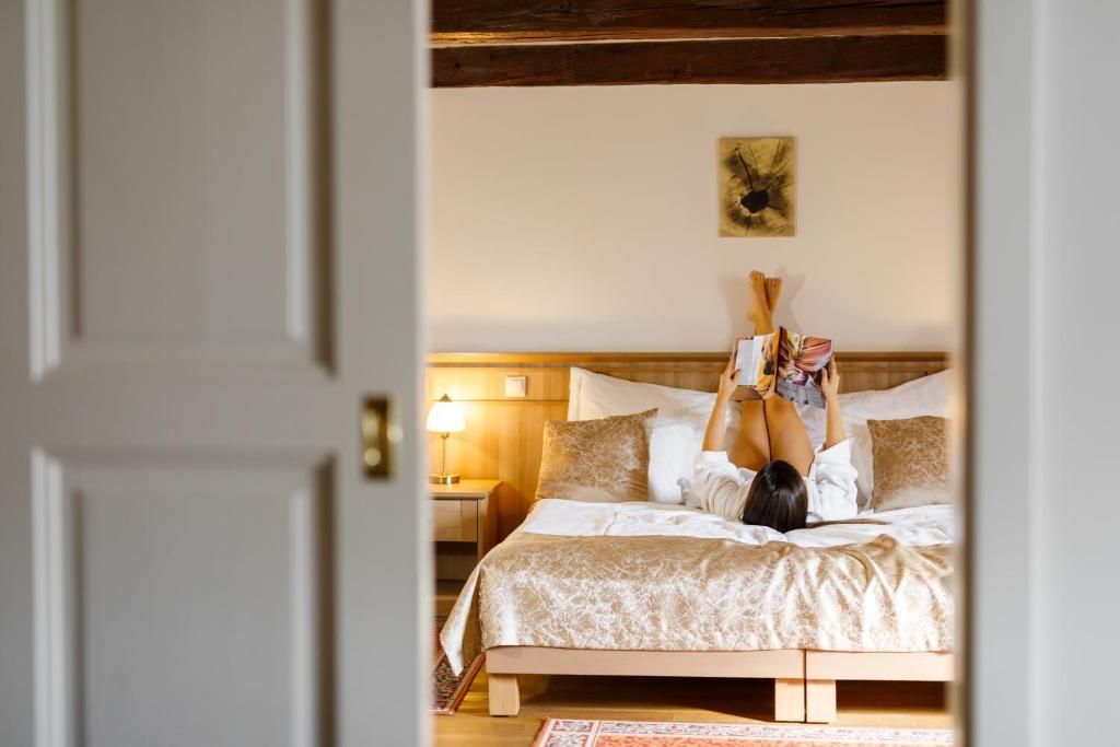 A bedroom with a bed, pillows, a nightstand, and a wall-mounted artwork.