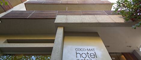 A modern building with a sign for 'Coco-Mati Hotel Nafiska'.