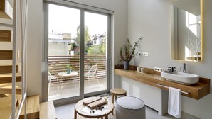 A modern bathroom with a large sliding glass door leading to an outdoor seating area. - COCO-MAT Hotel Nafsika (Kifisia)