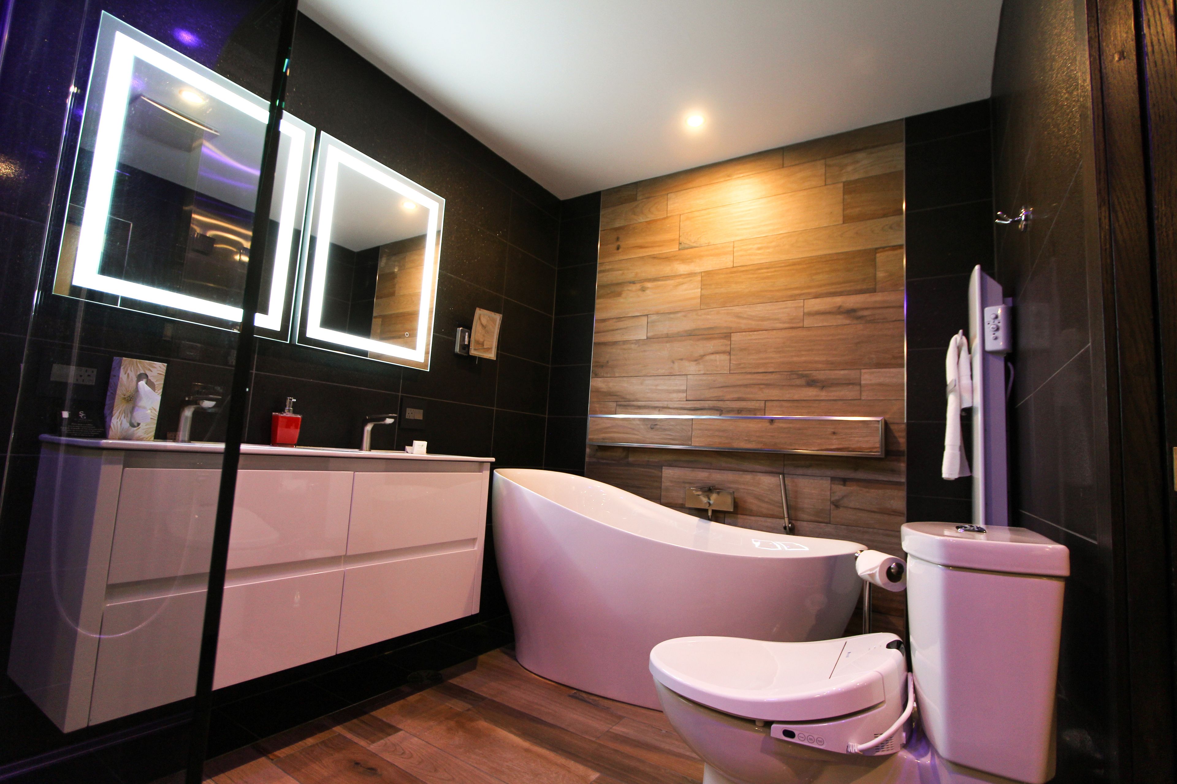 A modern bathroom with a vanity, a toilet, and a bathtub.