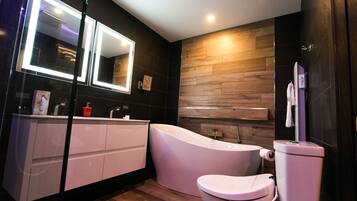A modern bathroom with a vanity, a toilet, and a bathtub.