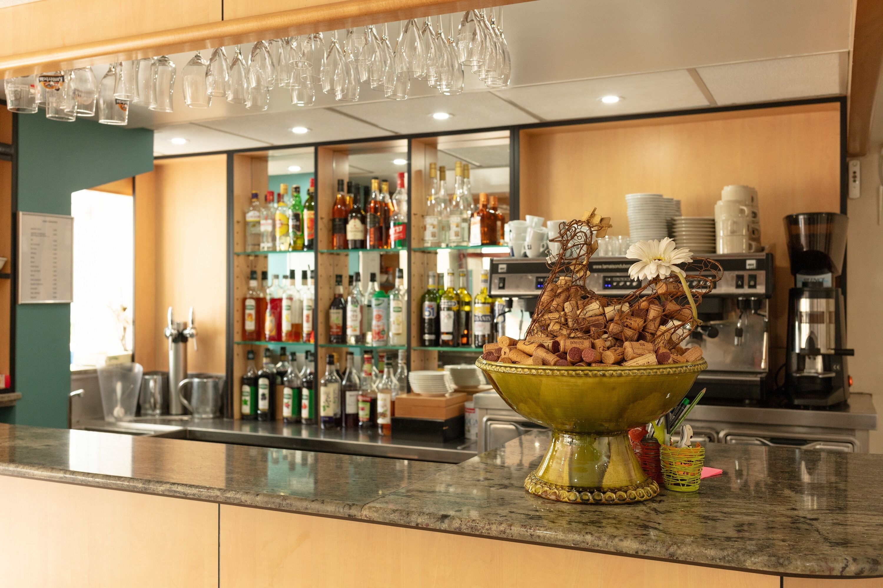 Una zona de bar con un bol de nueces y un arreglo floral en la barra.