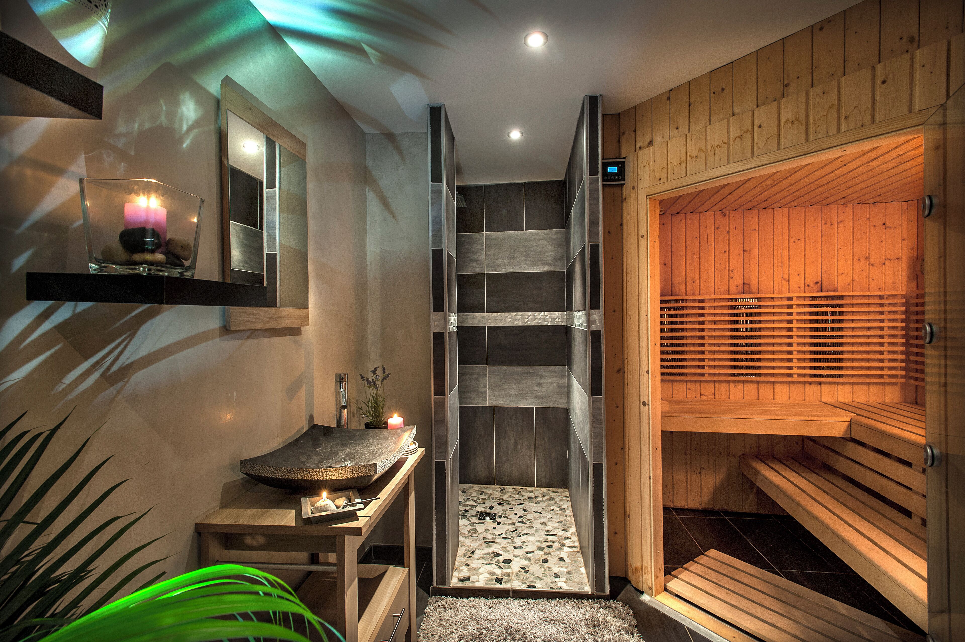 Una sauna amb seients de fusta, un recipient de vidre amb una espelma, i un mirall a la paret.