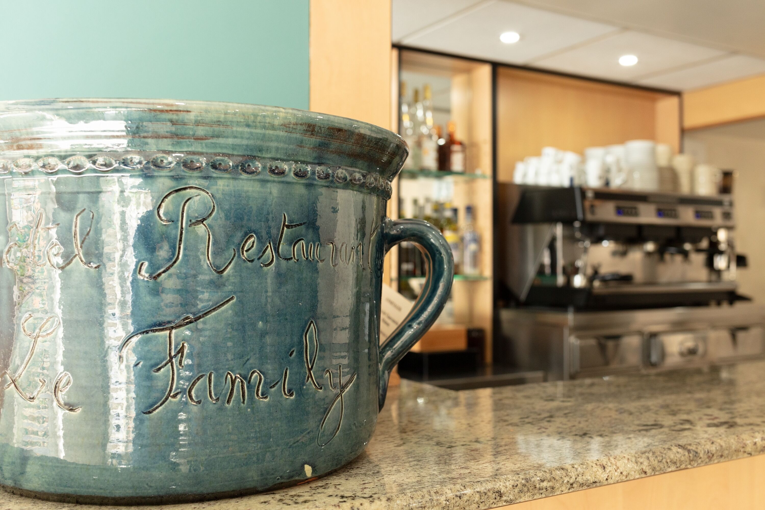 A ceramic mug with embossed text on a countertop.