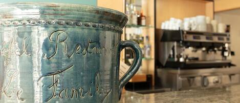 Una taza de cerámica con texto grabado sobre una encimera.