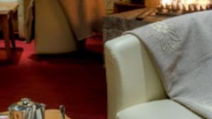 Una sala de estar acogedora con chimenea, un sofá y una mesa con tetera.