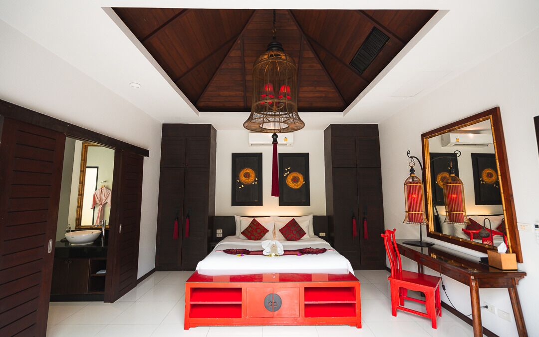 Ein Schlafzimmer mit Bett, Spiegel, Schreibtisch und Kleiderschrank.
