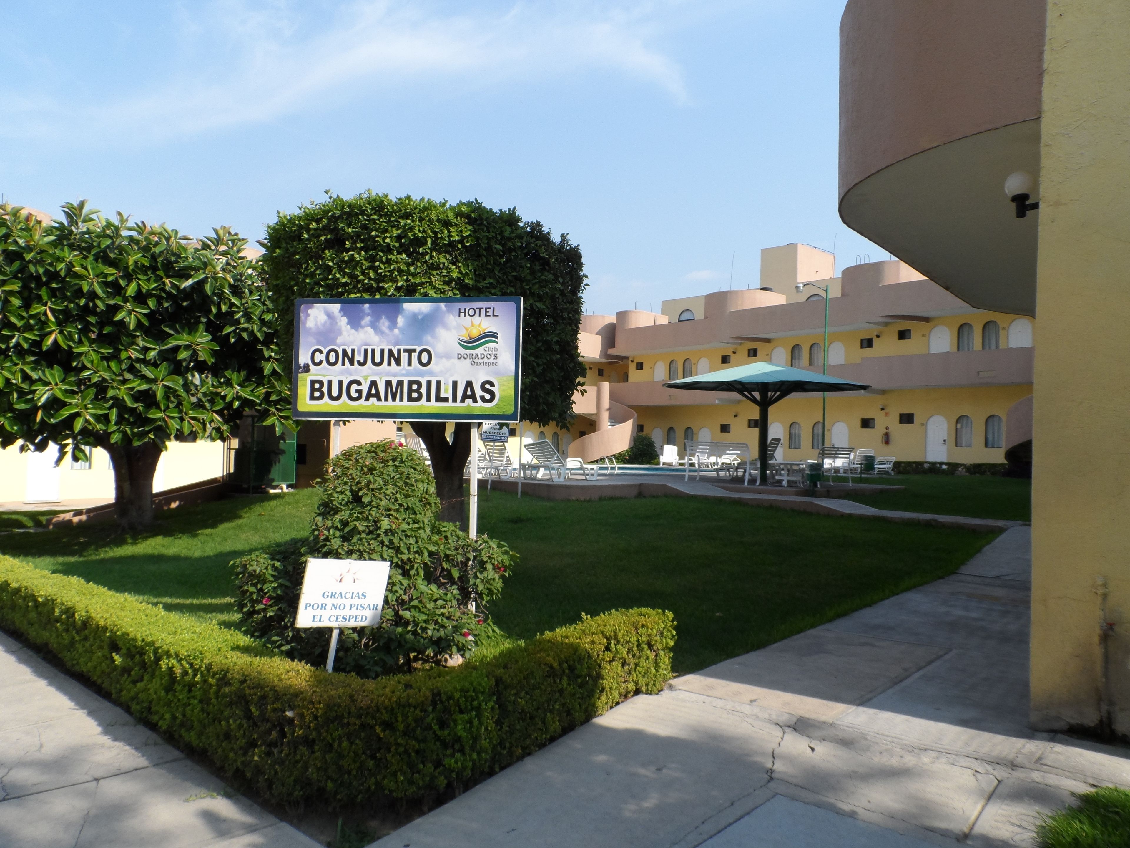 A hotel sign with a pool area in the background.