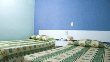 Una habitación con dos camas, cada una con ropa de cama verde y beige, una mesita de noche blanca y una pared azul.