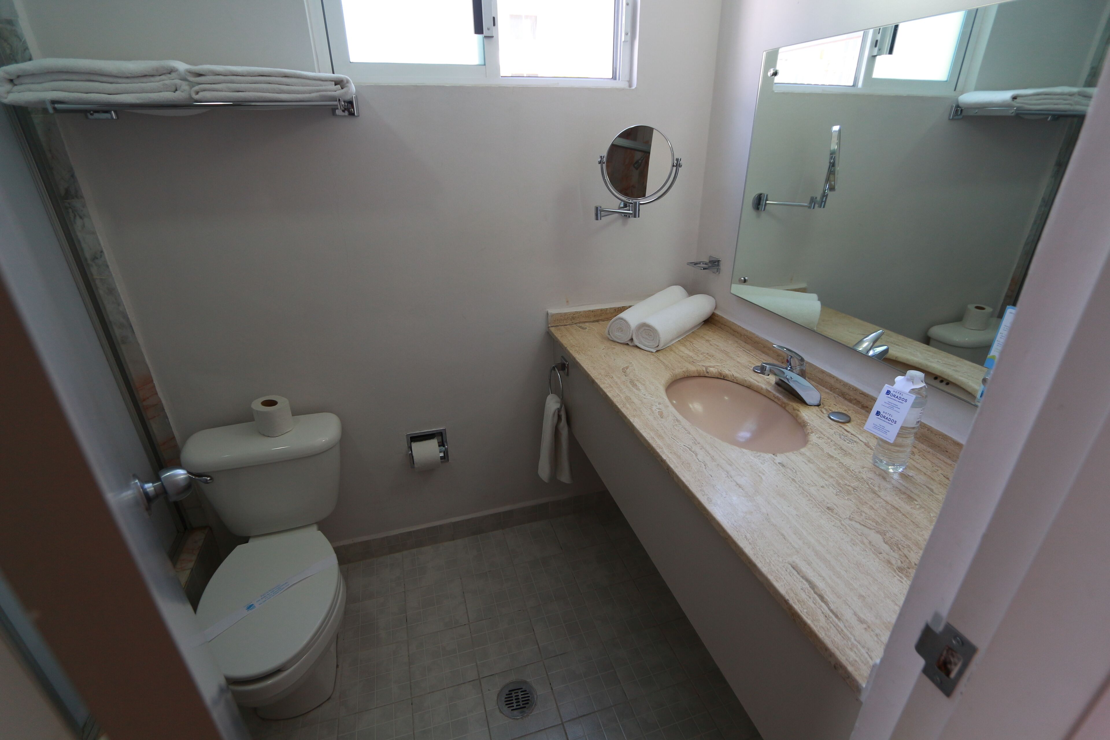 A small bathroom with a toilet, sink, and mirror.