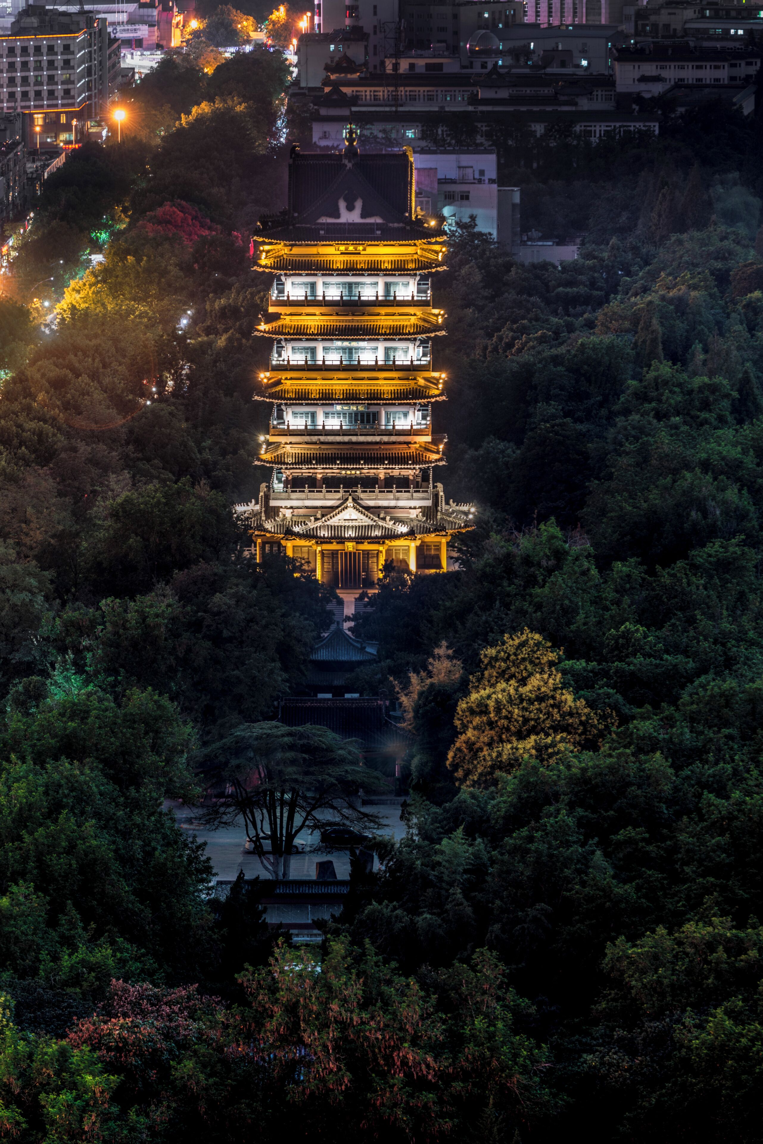 A multi-tiered pagoda-like structure surrounded by dense foliage, likely a historical or cultural landmark.