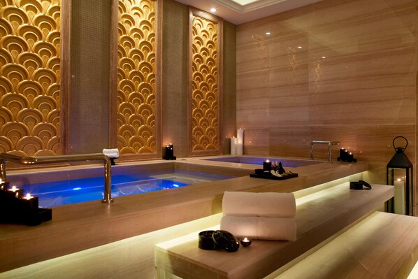 A spa area with two hot tubs, wooden benches, candles, and a modern design. - The Westin Hefei (Hefei)